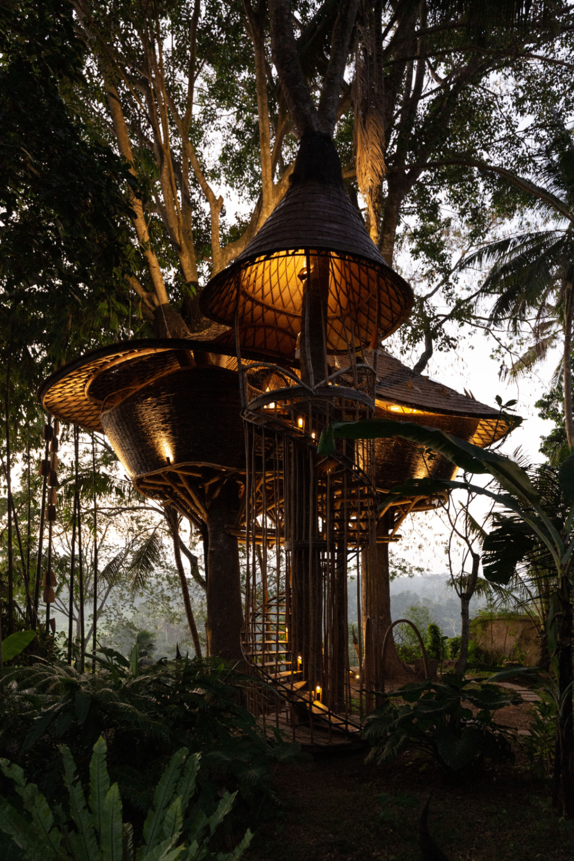 Bamboo tower lit at dusk inside the Ubud canopy